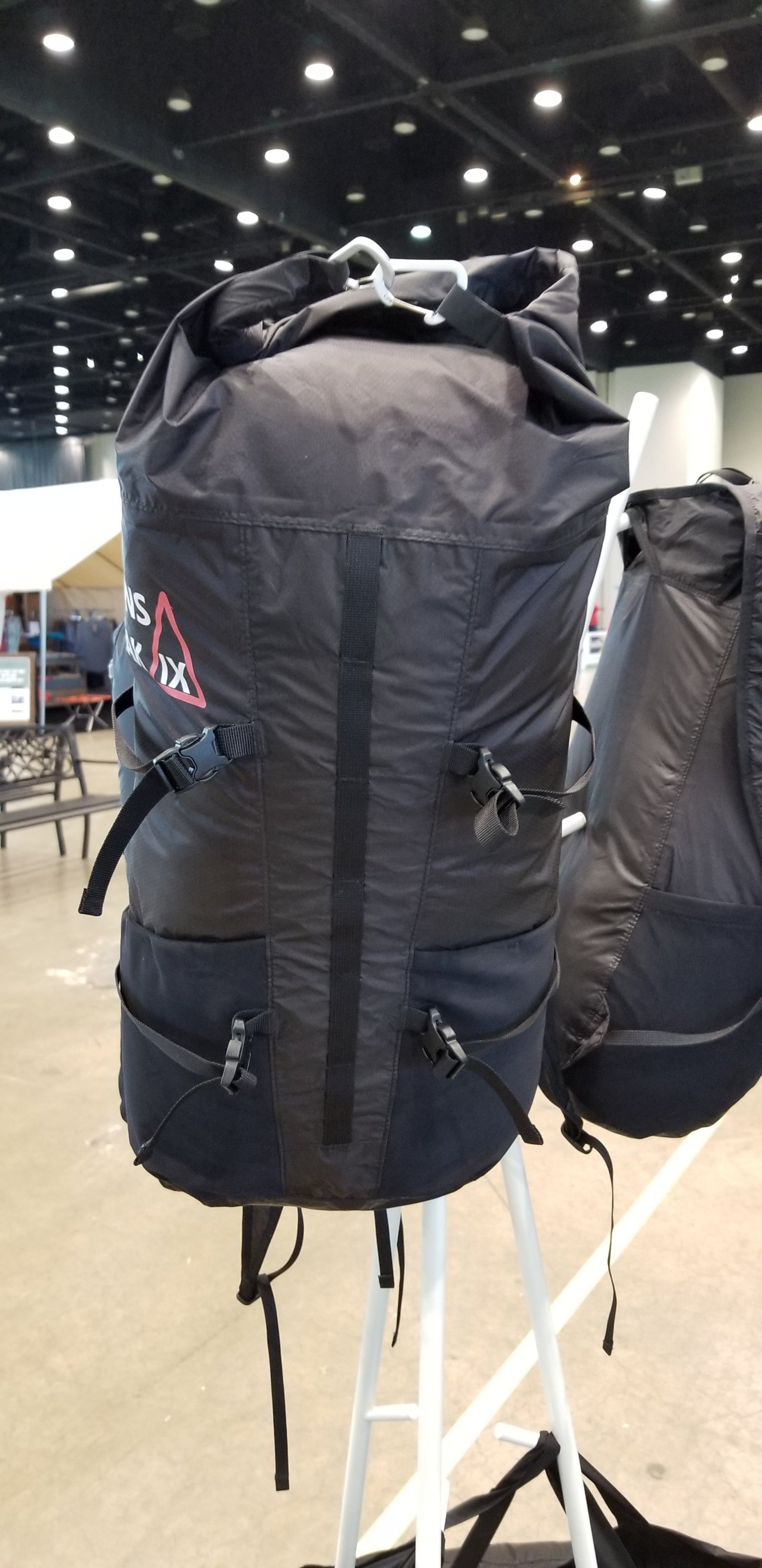 Black and orange Mons Peak IX adventure backpack, 28L capacity, tactical design with adjustable shoulder straps, side mesh pockets, and front organizer pockets for hiking and travel

