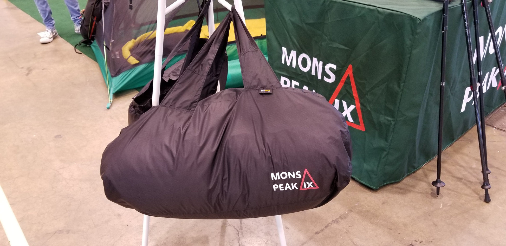 Mons Peak IX 40L black duffel bag front view with carry handles and shoulder strap
