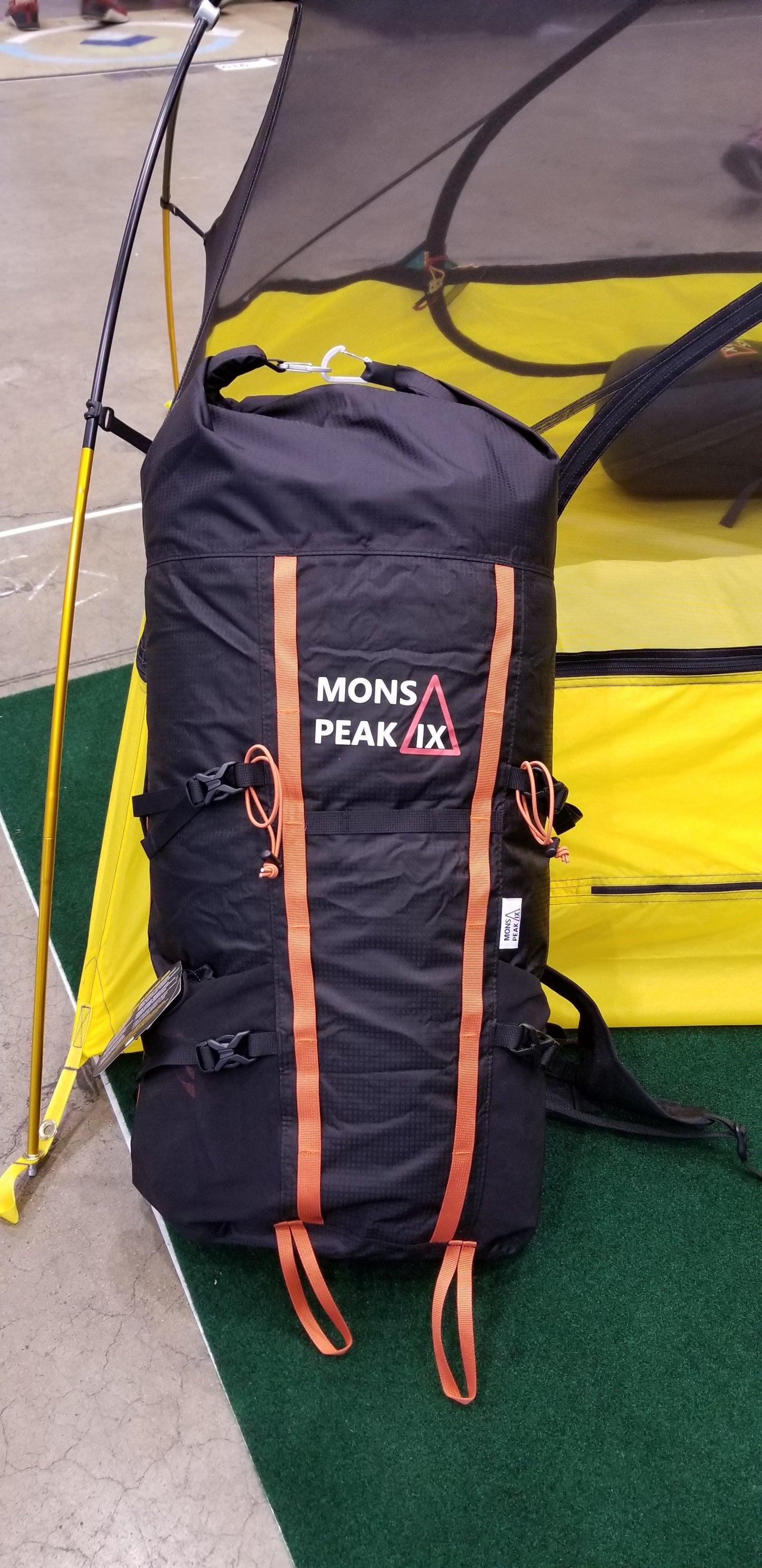 Black and orange Mons Peak IX adventure backpack, 28L capacity, tactical design with adjustable shoulder straps, side mesh pockets, and front organizer pockets for hiking and travel
