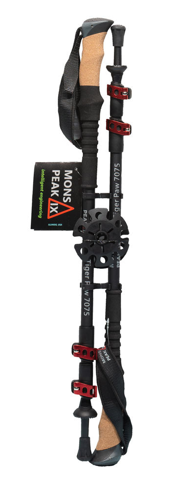 Mons Peak IX Tiger Paw Z carbon trekking pole fully extended with natural cork grip, black shaft, multiple red quick-lock collars, adjustable wrist strap, large mud/snow basket, carbide tip, and branded 'intelligent engineering' hang tag