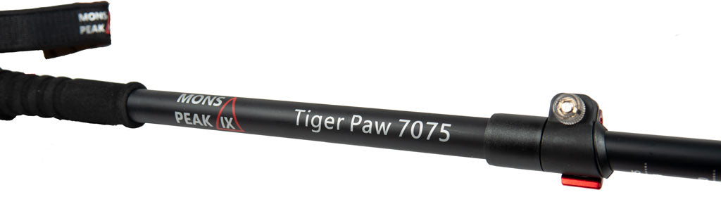 Close-up of Mons Peak IX Tiger Paw trekking pole shaft with printed branding 'Tiger Paw 70775', black foam grip extension, red quick-lock collar, and silver adjustment knob