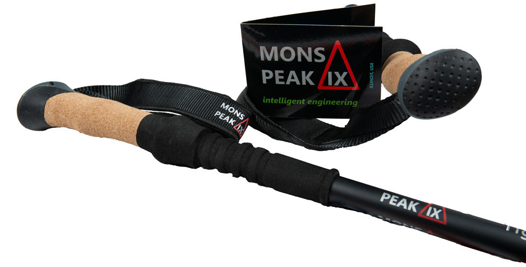 Tiger Paw trekking pole ergonomic cork grip by Mons Peak IX with black foam padding, nylon wrist strap, and black hang tag featuring 'intelligent engineering' logo and Illinois USA origin