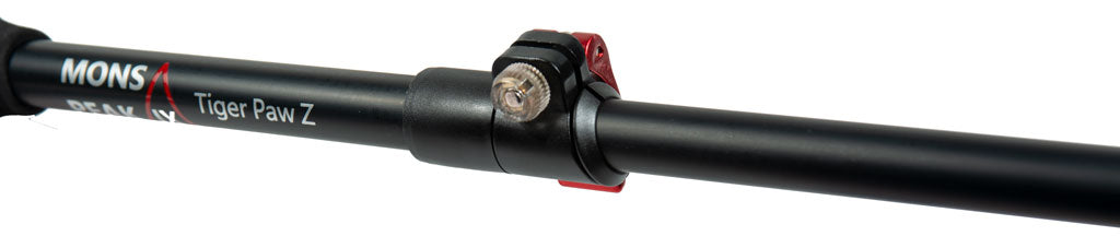 Close-up of Mons Peak IX Tiger Paw Z trekking pole quick-lock mechanism: black carbon shaft with branding, red anodized collar, and knurled silver tightening knob