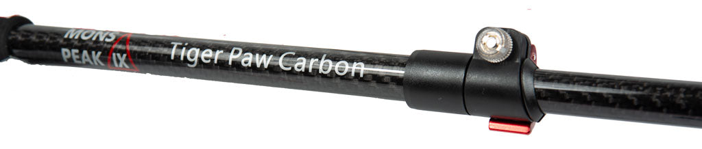 Close-up of Mons Peak IX Tiger Paw Z trekking pole quick-lock mechanism: black carbon shaft with branding, red anodized collar, and knurled silver tightening knob